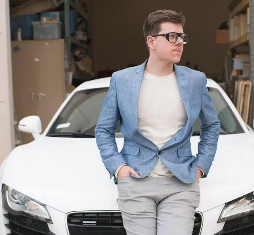 Crypto millionaire Erik Finman poses with his white Audi R8